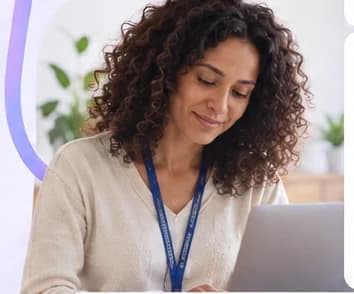 Educadora sorrindo enquanto registra uma observação no notebook